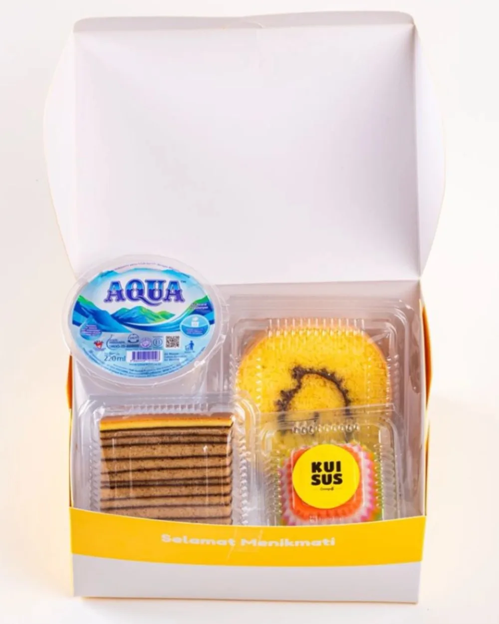 Snack box KUISUS terbuka: lapis legit, bolu gulung, kue sus, dan air mineral